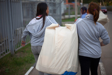 Children are carrying a heavy bag. Teens are dragging their belongings.