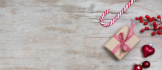 Christmas Background Banner. Christmas ornaments on wooden background, red bauble balls, a small gift