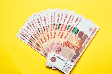 A lot of Russian money banknotes rubles on a yellow background