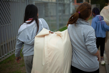 Children are carrying a heavy bag. Teens are dragging their belongings.