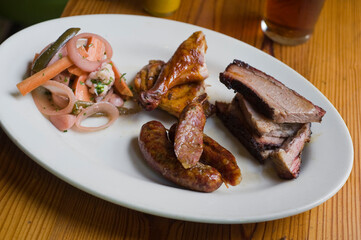 Barbecue catering platter with variety of meats. Traditional Texas BBQ: Beef brisket, beef ribs, pork ribs, sausage links, black pepper roasted chicken, and turkey served with homemade sauce.