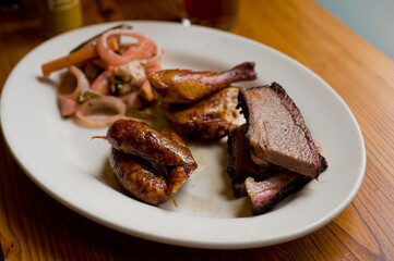 Barbecue catering platter with variety of meats. Traditional Texas BBQ: Beef brisket, beef ribs, pork ribs, sausage links, black pepper roasted chicken, and turkey served with homemade sauce.