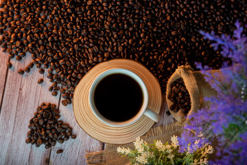 Coffee cup and coffee beans with old wooden background