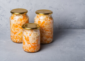 Homemade sauerkraut in a glass jar on a gray background. Fermented product Marinated cabbage.The best natural probiotic.
