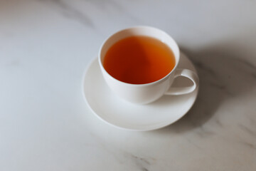 Top view of a cup of hot tea with copy space.Hot tea is in a white glass placed on a white background. There is space for the message. White background.