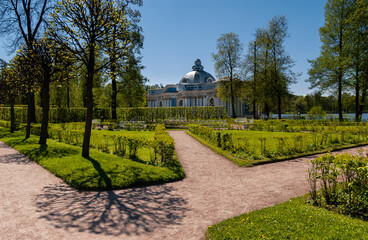Patterned shadows of trees, pink paths, White, blue pavilion «Grotto» with a dome on a background...