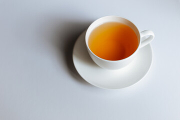 Top view of a cup of hot tea with copy space.Hot tea is in a white glass placed on a white background. There is space for the message. White background.
