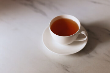 Top view of a cup of hot tea with copy space.Hot tea is in a white glass placed on a white background. There is space for the message. White background.