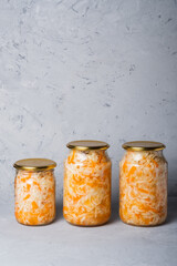 Homemade sauerkraut in a glass jar on a gray background. Fermented product Marinated cabbage.The best natural probiotic.