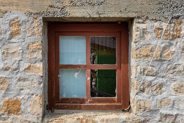 Fototapeta na wymiar Vintage wooden window on a rustic cabine stone wall