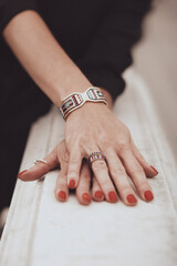 Female hands with red manicure and accessories. Fashion details