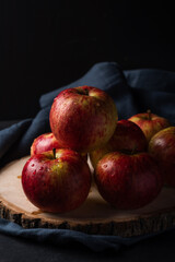 Fototapeta na wymiar Red apples on a wooden board on a dark background. Natural product. Healthy eating.