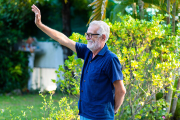 family time together at home concept. lifestyle. Portrait of happy and handsome bearded senior man in glasses enjoy nature garden at home. Elder man