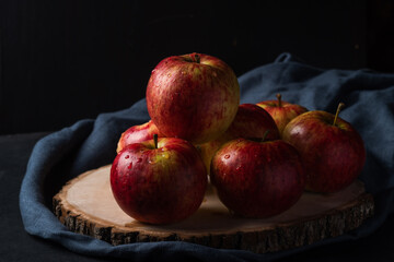 Red apples on a wooden board on a dark background. Natural product. Healthy eating.