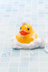 A toy duck covered in foam taking a bath