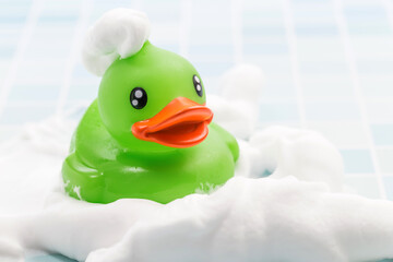 A toy duck covered in foam taking a bath