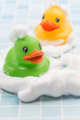 A toy duck covered in foam taking a bath