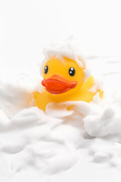 A toy duck covered in foam taking a bath