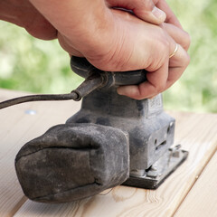 Carpenters use tools for wood products. Processing of the wooden surface of the table.