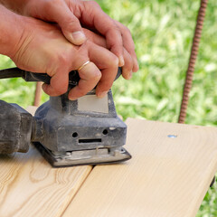 Carpenter works with a tool. Close-up of hands and woodworking tools.