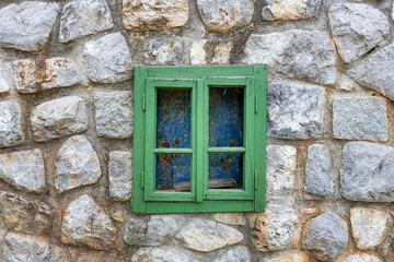 Vintage wooden window on a rustic cabine stone wall