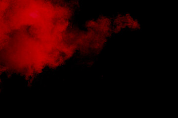 Fototapeta na wymiar Red powder explosion on black background. Freeze motion of red dust particles splash.