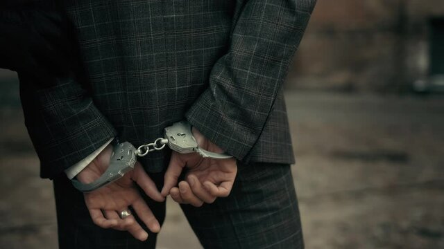 The police take the handcuffed prisoner to the prison. Detention of a suspect. Back view