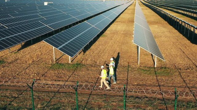 Top view of a photovoltaic power plant with a group of engineers