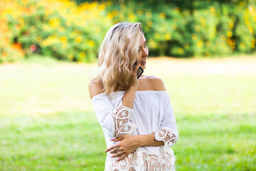 Fototapeta premium Young beautiful woman in park talking on cell phone.