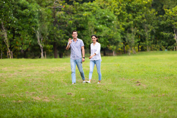 Naklejka na ściany i meble Romantic couple in love concept. Young couple enjoying walking a day at the park