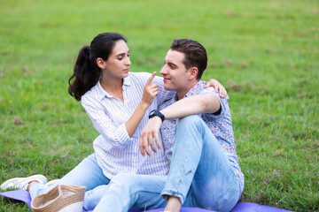 Naklejka na ściany i meble Romantic couple in love concept. Young happy couple enjoying picnic at the park on a holiday.