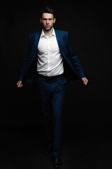 Handsome man wear blue suit isolated on black background