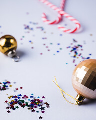 Fototapeta premium Christmas or New Year Background with Gold Christmas Balls Confetti and Candy Cane Blue Background Vertical Festive Frame