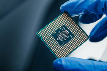 Close-up view on a new semiconductor microchip in gloved hand of computer scientist. Modern...
