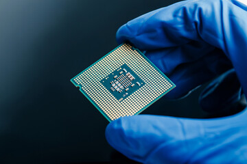 Close-up view on a new semiconductor microchip in gloved hand of computer scientist. Modern...