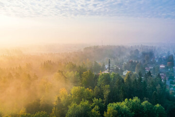 Drone view of a foggy morning with forest and suburbs in Finland