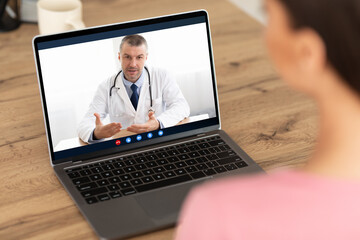 Woman having video chat with doctor on laptop at home