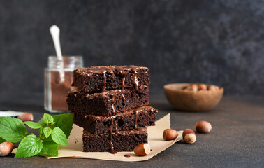 The classic American cake is brownie. Chocolate cake with nuts on a black background.