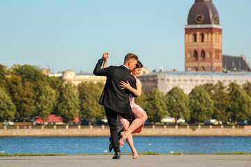 Young couple dancing tango against the old city background. Travel and lifestyle concepts