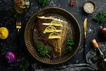 Baked flounder fish with lemon and spices on a metal baking dish. Seafood. Top view. Free space for text.