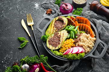 Vegan bowl: quinoa, avocado, pumpkin with beans and corn in a black bowl. Diet. Top view. Free space for text.