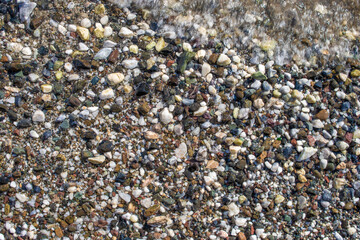 Pebbles and Foam. stones and sea. Pebbles stones texture