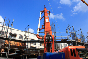 建設工事現場の足場と生コンポンプ