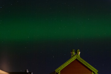 A little green northern light in Norway over a house