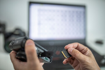 Fotograf nimmt am Computer die Speicherkarte aus einer Kamera