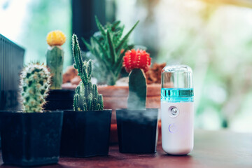 Alcohol nano mist sprayer for hand cleaning to prevent the spread of the Corona virus (Covid-19) to serve customers at coffee shop. Modern health technology. New normal lifestyle. Selective focus
