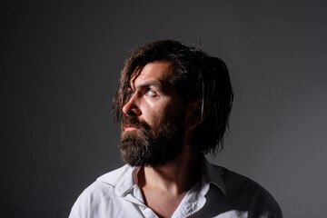 Brutal bearded man. Silhouette handsome man. Barber Shop. Fashion. Trendy clothes. Bearded man in white shirt. Pensive man.