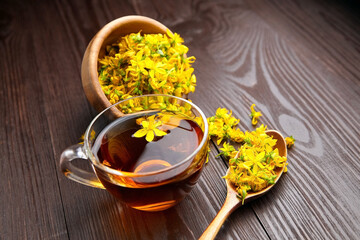 Cup with hypericum perforatum or St Johns wort tea with fresh flowers