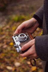 Rare camera in hands in autumn park