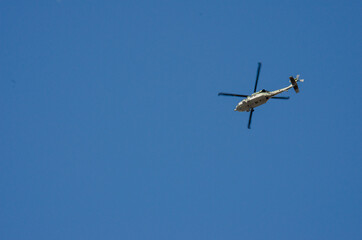 Fototapeta na wymiar helicopter flying on blue sky